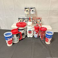 Group shot showing entire assortment of Coca-Cola glass and plastic tumblers