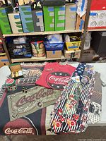 Group shot of blanket, T-shirt, four ties, tin, keychain assortment and boxed watch