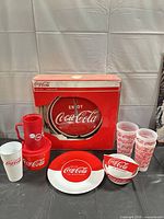 Full lot showing clock box, plate, bowls, tumblers, mug, and lidded container