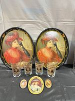 Front view of both trays, four glasses and three tins