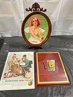 Front view of tray on easel alongside paper ad and wood plaque with lock