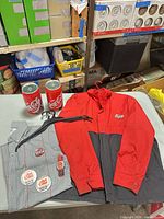 Group shot of jacket, shirt on hanger, two coin banks, buttons, watch