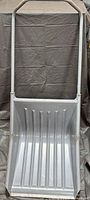 Front view of gray plastic snow pusher showing scoop and handle