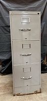 Front view of gray 3-drawer file cabinet showing handles and label holders
