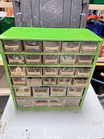 front view of green metal cabinet showing 5 rows of small drawers and 1 large bottom drawer