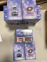 Stack of boxed LED rotating display bases on table