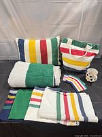 Group shot showing pillow, tote, folded towels, mug and coasters