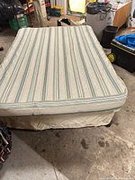 Mattress on frame with fabric skirt cover in place