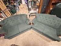 Both loveseats arranged together showing upholstery pattern, wood arm accents, overall wear
