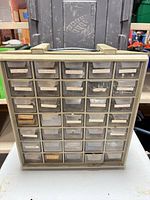 Front view of cabinet showing beige frame, three columns of clear drawers