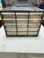 Front view of black plastic organizer showing all 15 clear drawers