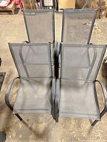Four stacked patio chairs showing overall style and color