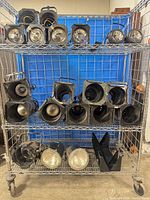 Full lot on wire rack showing 18 par cans with lenses and yokes plus loose parts