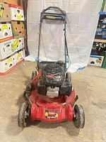 Front view of Toro mower showing deck, wheels, handle