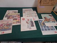 Overview of all vintage Coca-Cola ads on table