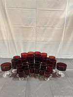 Front view of all 26 ruby red stemmed glasses grouped by size