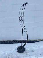 Full side view of wrought and cast iron trellis showing overall height and curved form