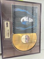 Full view of framed gold record plaque showing record, album art, nameplate, frame