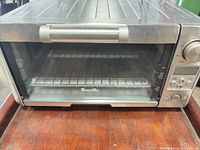 Front view of Breville Mini Smart Oven showing stainless exterior, glass door and handle