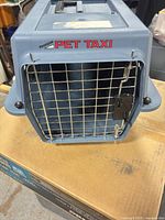 Front view showing Petmate Pet Taxi branding, metal wire door and latch
