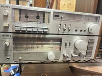 Front view of Sony TC-K22 cassette deck stacked on Sony STR-V25 receiver showing controls, meters and brushed aluminum faces