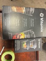 Sealed box of Vitamix 48-ounce container beside sealed box of blending bowls accessory