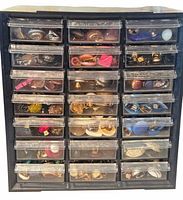 Front view of plastic drawer organizer filled with numerous pairs of clip-on earrings