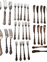 Group of forks and butter spreaders showing tarnish and partial polish
