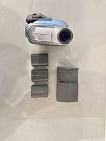 Camcorder front with lens, three batteries, charger