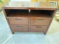 Front view showing four drawers, open shelf and overall design