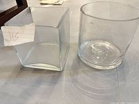 Square and round clear glass vases side by side