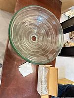 top view of clear glass vessel sink showing center drain opening and ridged design