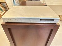 Front view of Daenyx DVD-807 showing tray, buttons, model marking and cosmetic wear