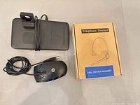 Overview of all three items: boxed telephone headset, HP USB mouse, docking base