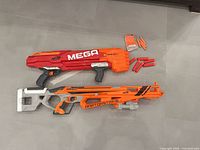 Both blasters side by side with darts and clip on floor