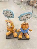 Front view of both Garfield figurine note holders with signs visible
