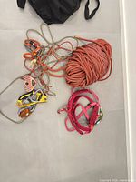 overview of rope coil, carabiners, pulley, belay device and harness