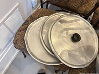 Three stacked aluminum lids, showing size and knobs