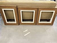 All three matching gold ornate frames standing side by side