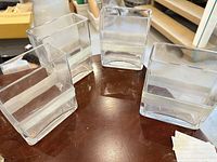 Four square clear glass vases on table