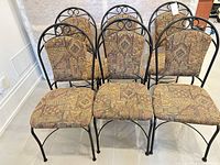 Front view of all six metal frame dining chairs with multicolor upholstery
