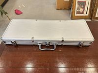 Top view of closed rectangular silver aluminum case with handle and latches