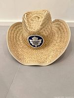 Front view of straw cowboy hat showing Maple Leafs patch and overall shape