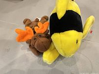 Brown Ty Beanie Babies Chocolate moose plush beside yellow striped plush