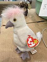 Full view of Kuku cockatoo plush with hang tag visible