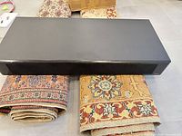 Front and top view of black center channel speaker with grille