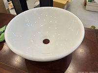 Overall view of white ceramic vessel sink showing shape and drain hole