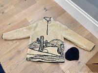 Full view of sherpa jacket and beanie on floor