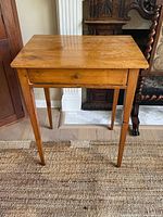 Front view of antique cash drawer table showing drawer and tapered legs