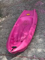 Full view of pink child kayak on driveway
